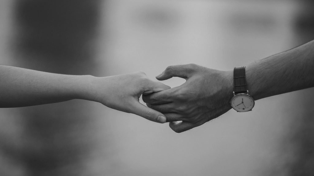 Dos manos que se buscan y se entrelazan, símbolo de reconciliación en el matrimonio